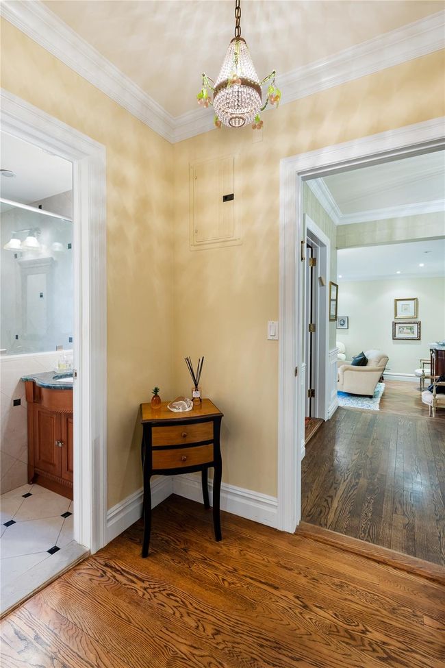 Corridor featuring a chandelier, wood finished floors, and ornamental molding | Image 18