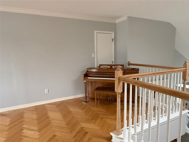 Living area with crown molding, baseboards, and an upstairs landing | Image 34