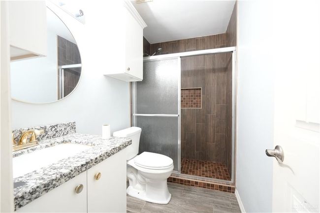 Bathroom with vanity, a stall shower, and wood finish floors | Image 12