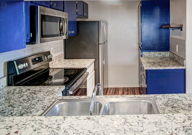 Kitchen with decorative backsplash, light countertops, blue cabinets, and appliances with stainless steel finishes | Image 7