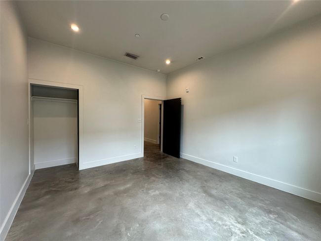 Unfurnished bedroom with finished concrete floors, a closet, and recessed lighting | Image 34