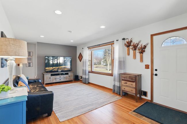 Hardwood floors and recessed lighting elevate the atmosphere in the living room. | Image 4