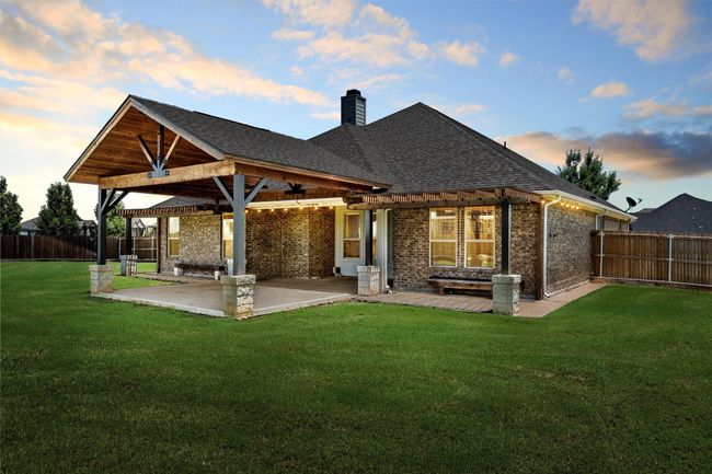 Back of house featuring brick siding, a fenced backyard, a chimney, a patio, and a pergola | Image 29