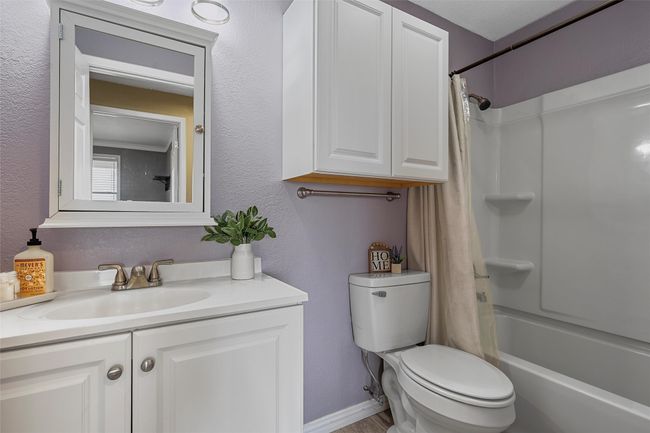 Bathroom with vanity, shower / tub combo with curtain, and a textured wall | Image 18