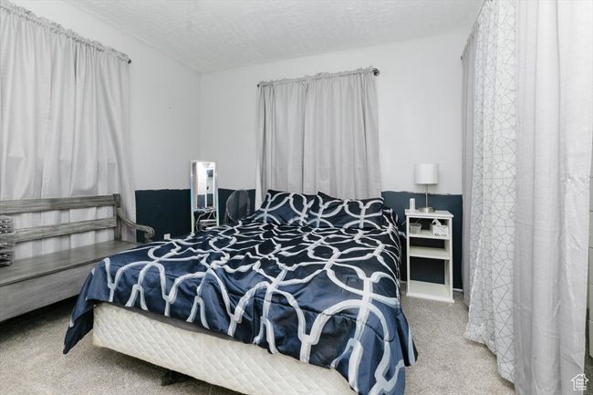Bedroom featuring a textured ceiling and carpet flooring | Image 17