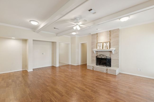 Spacious open living area with engineered hardwood flooring and high quality gas fireplace logs | Image 10