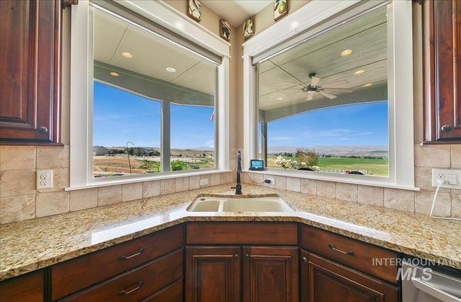 Kitchen with stainless steel dishwasher, decorative backsplash, ceiling fan, light stone countertops, and recessed lighting | Image 13