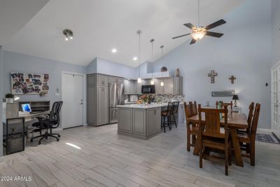 The remodeled kitchen has custom cabinets, quartz counters and opens up to the dining area with fireplace. | Image 2