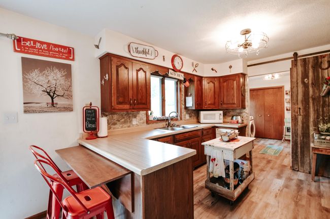 An adjustable counter -top has the ability to fold down or keep up(as shown) New flooring throughout main level accept the main level bath. The kitchen wooden island does not stay(it is not attached and is on wheels) | Image 8