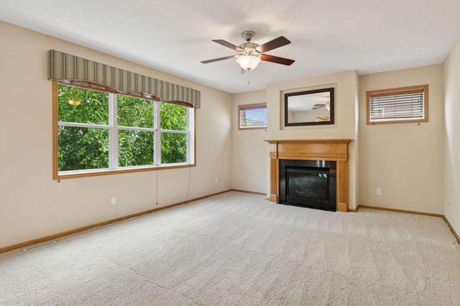 The living room has a cozy gas fireplace and looks over the backyard | Image 6