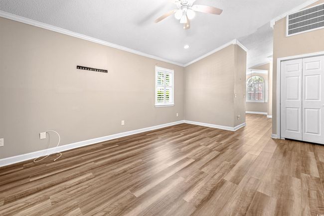 Unfurnished bedroom featuring visible vents, ornamental molding, wood finished floors, baseboards, and a ceiling fan | Image 28