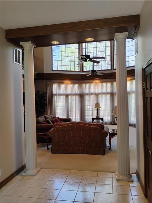 Living room featuring visible vents, ornate columns, ceiling fan, and light tile patterned floors | Image 18