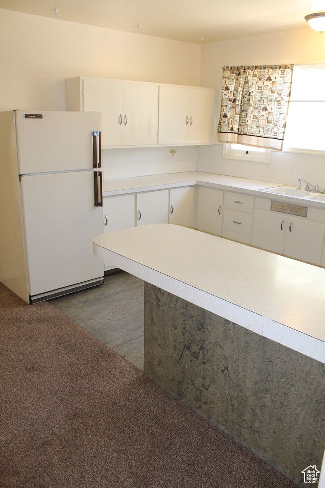 Kitchen featuring freestanding refrigerator, white cabinetry, light countertops, and dark wood-style flooring | Image 29