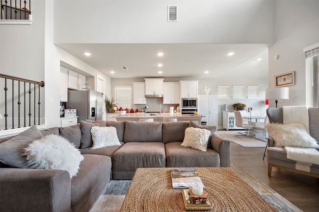Living room with light wood-style flooring, a towering ceiling, and recessed lighting | Image 28