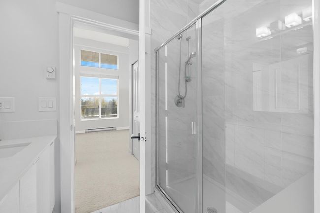 Bathroom featuring baseboards, a shower stall, vanity, and baseboard heating | Image 18