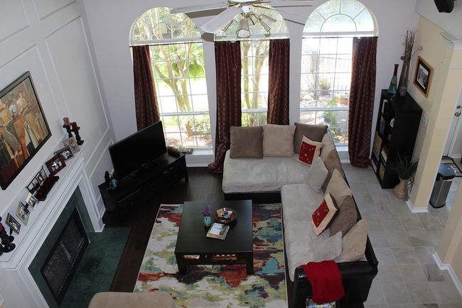 Living area featuring a fireplace, ceiling fan, and plenty of natural light | Image 9