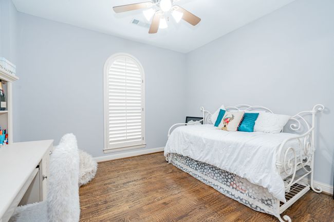 Bedroom featuring wood finished floors, baseboards, and a ceiling fan | Image 26