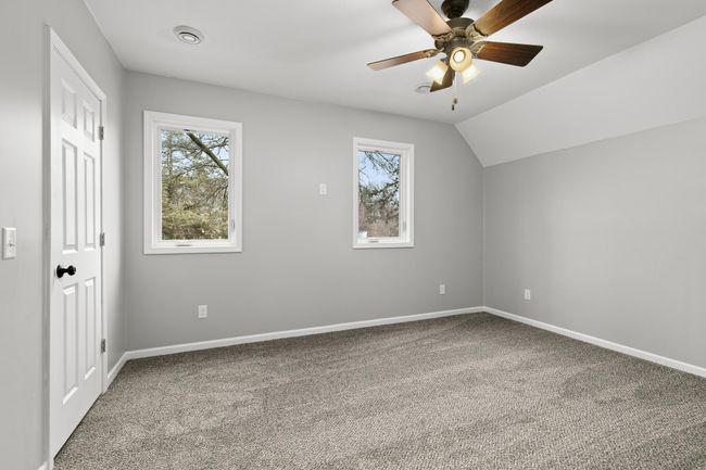The primary bedroom is spacious with generously sized closet and ceiling fan. | Image 21