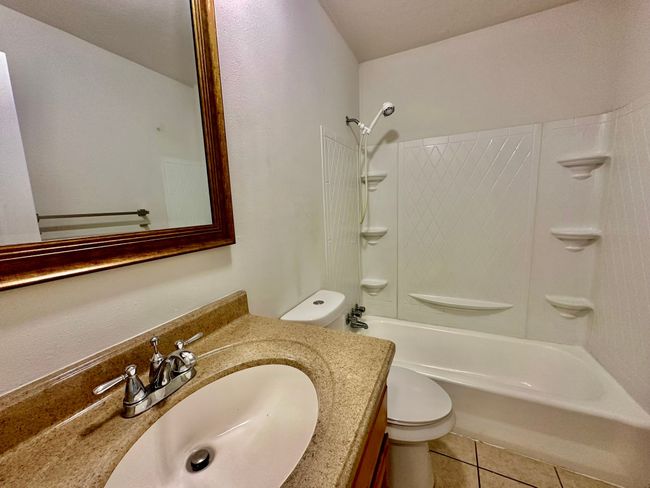 Bathroom featuring vanity, washtub / shower combination, and tile patterned floors | Image 8