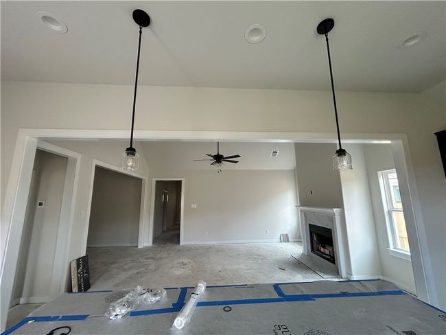 Unfurnished living room with lofted ceiling, recessed lighting, a high end fireplace, and a ceiling fan | Image 6