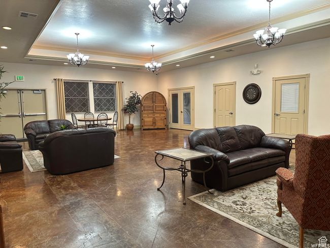 Living room featuring a chandelier, a raised ceiling, recessed lighting, and crown molding | Image 38