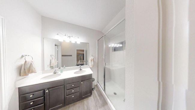 Bathroom with wood finished floors, double vanity, and a shower stall | Image 26
