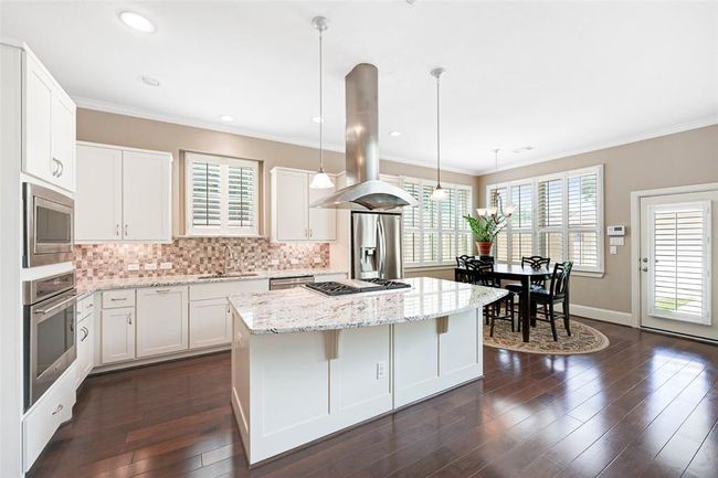 updated kitchen with island seating, stainless steel Monogram appliances, and a breakfast area—ideal for everyday living and entertaining. | Image 9