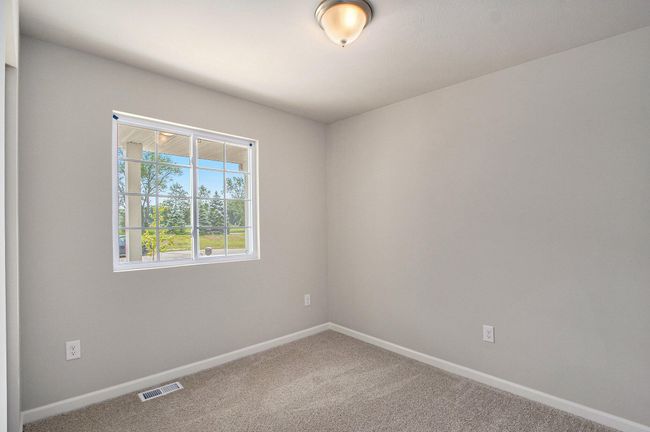The second bedroom is in the front of the home, opposite the foyer and kitchen. This large room can serve as an office, exercise space or guest bedroom. | Image 15