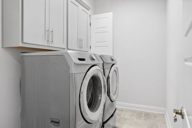 The laundry room offers dual accessibility from the hallway and primary bedroom closet. | Image 30