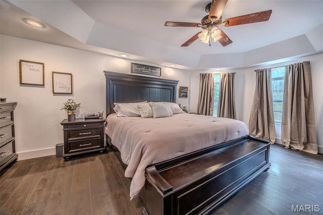 Bedroom featuring dark wood finished floors, a ceiling fan, a tray ceiling, and recessed lighting | Image 28