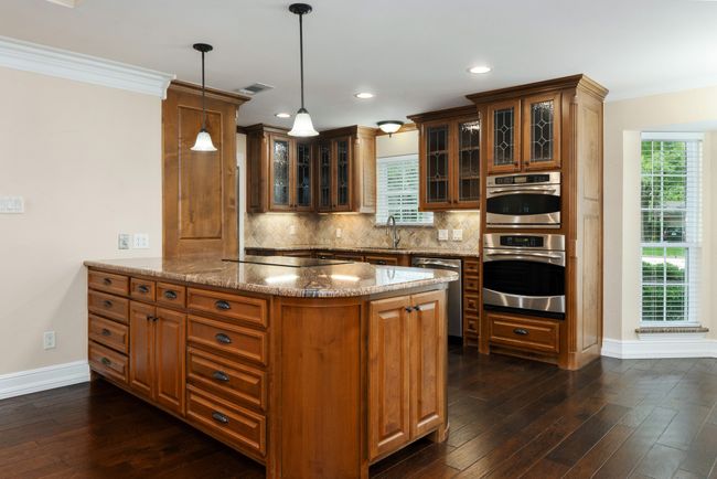 Kitchen with appliances with stainless steel finishes, a peninsula, tasteful backsplash, dark wood-type flooring, and crown molding | Image 13