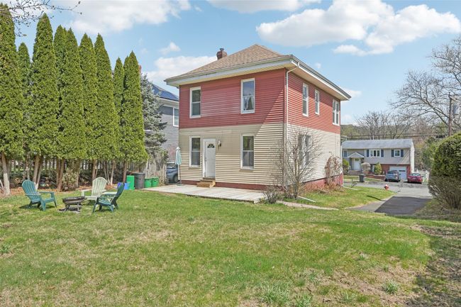 Back of house featuring entry steps, a chimney, and a yard | Image 36