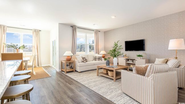 Living area with baseboards, wallpapered walls, wood finished floors, and a wealth of natural light | Image 10