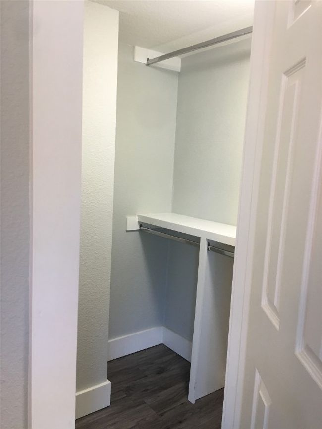 Walk in closet with dark wood finished floors | Image 8