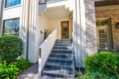 Enter the home via a stairway leading to the elevated front door, suggesting added privacy and security. The door at street level opens to the work/office space. This space is also accessible from inside the residence. | Image 3