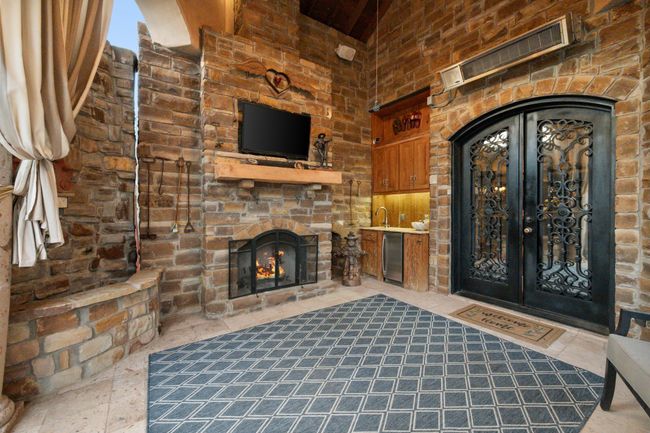 Covered patio with fireplace and overhead gas heater | Image 36