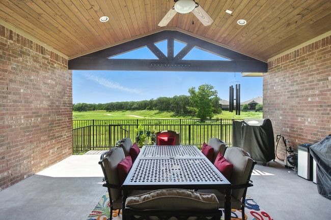 View of patio / terrace with a ceiling fan, a grill, golf course view, and outdoor dining space | Image 32