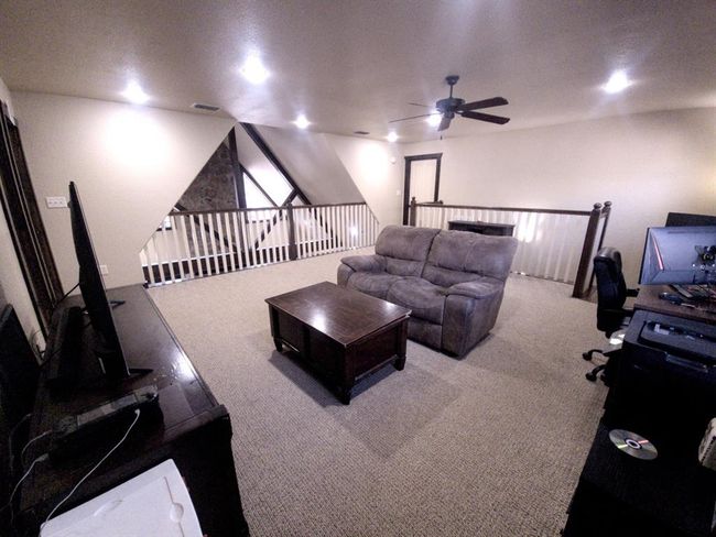 Oversized upstairs game room features recessed lighting and overlooks the downstairs family room | Image 11