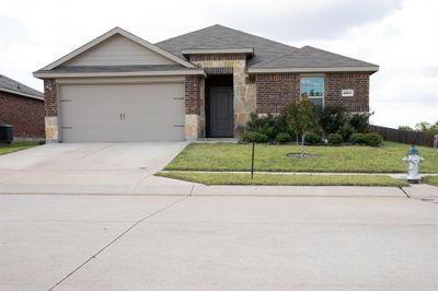 Single story home featuring a garage, a front yard, and central air condition unit | Image 1