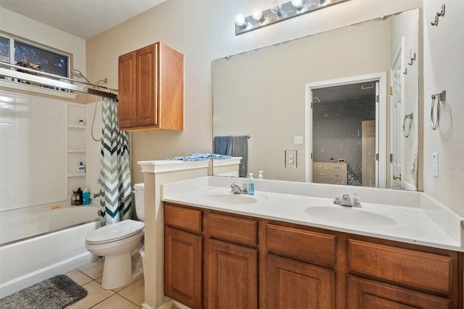Spacious primary suite on the back of the house for added privacy offers a walk in closet, dual vanities, linen closet plus a window over the shower and tub providing natural light. Recent upgrades include vinyl plank flooring, water heater, range, roof and HVAC. | Image 25