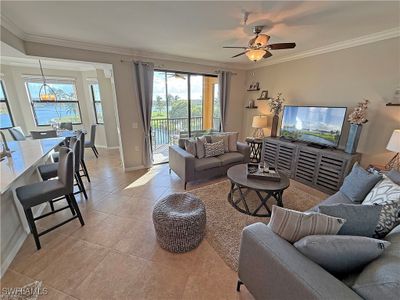 Living room featuring crown molding, tile floors, and ceiling fan | Image 2