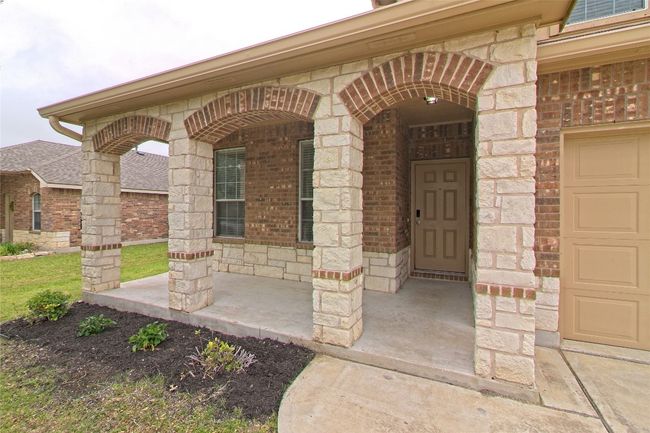 View of exterior entry with brick siding, stone siding, and a porch | Image 4