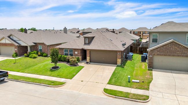 View of front of property featuring brick siding, a residential view, concrete driveway, roof with shingles, and a garage | Image 33