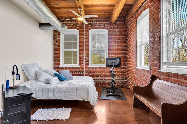 bedroom with beamed ceiling, brick wall, wooden ceiling, and concrete floors | Image 14