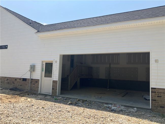 Rear view of property with a garage, a shingled roof, brick siding, and driveway | Image 5