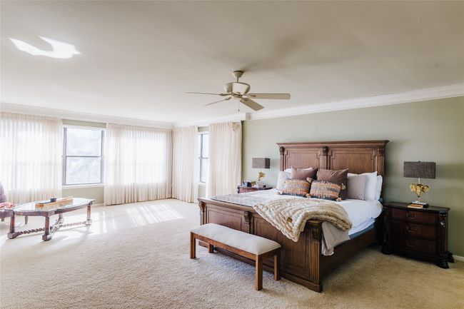 Bedroom featuring ceiling fan, light colored carpet, and crown molding | Image 26