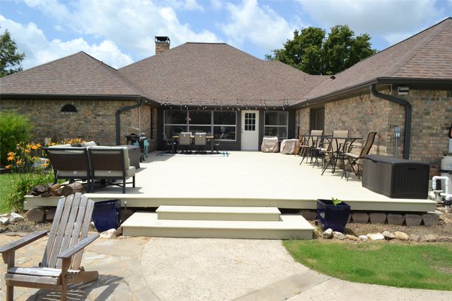 Back of property featuring outdoor dining area, a wooden deck, a chimney, brick siding, and an outdoor living space | Image 31