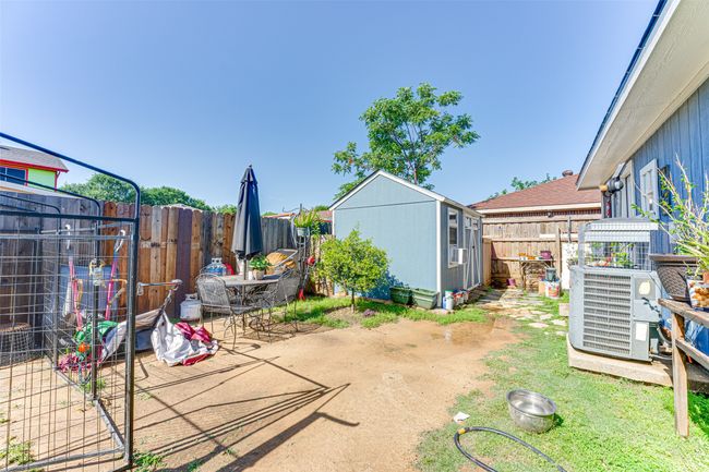 View of yard with a fenced backyard, an outdoor structure, a patio area, and a gate | Image 21