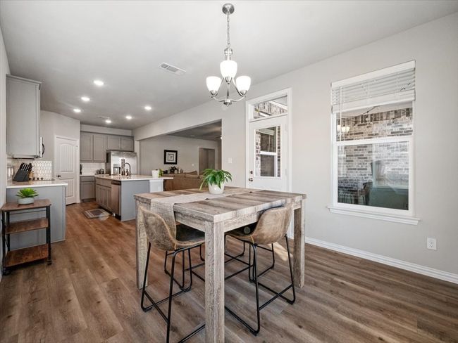 Dining area featuring dark wood finished floors, visible vents, baseboards, and recessed lighting | Image 9
