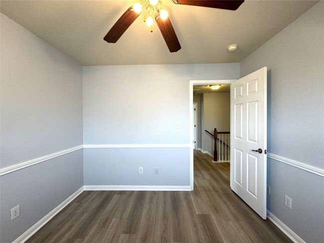 Spare room with ceiling fan, dark wood finished floors, and a textured ceiling | Image 13